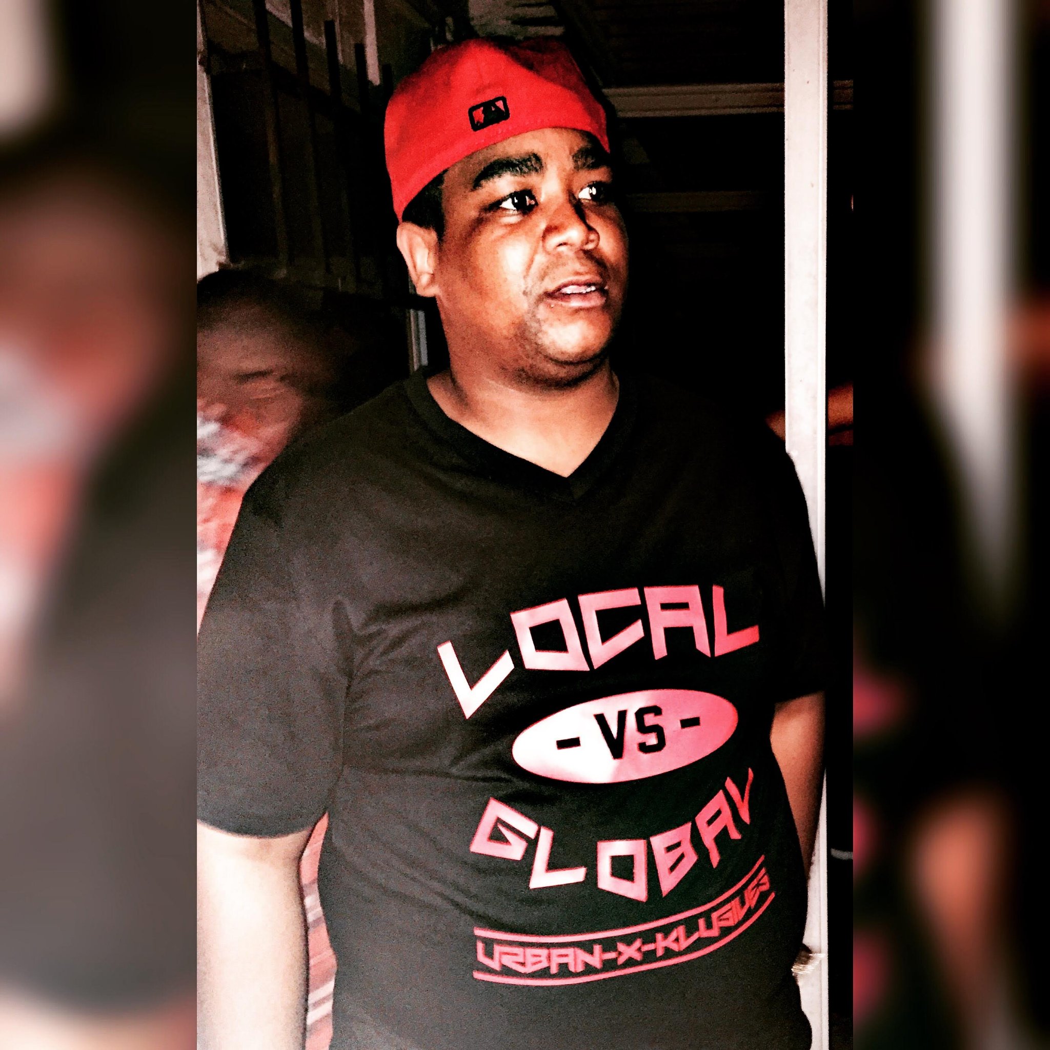 Trav's cousin wearing the Local vs Global UXK tee and a red cap